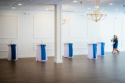 Empty event space with decorated high-top tables; event technology
