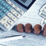 a calculator, pen, and money on a table; ERP integration