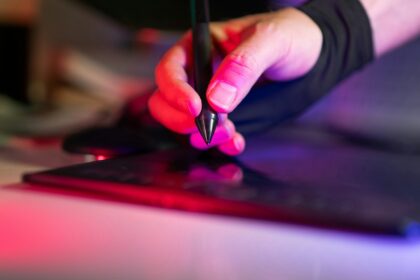 A person using a pen to write on a laptop; career skills