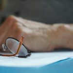 brown framed eyeglasses on blue textile; Medicare open enrollment