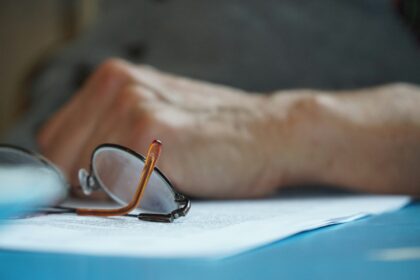 brown framed eyeglasses on blue textile; Medicare open enrollment