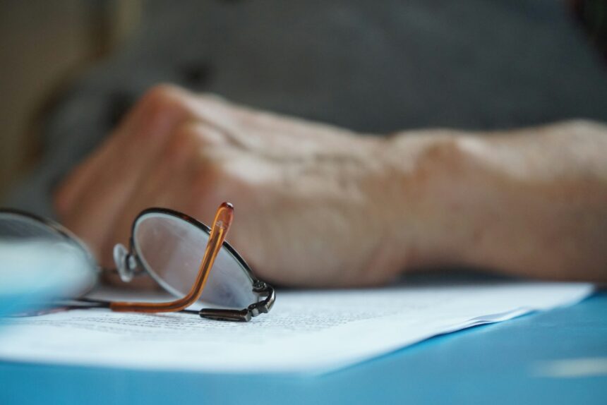 brown framed eyeglasses on blue textile; Medicare open enrollment