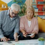 Elderly couple reviewing documents at home; social security trust fund 2032