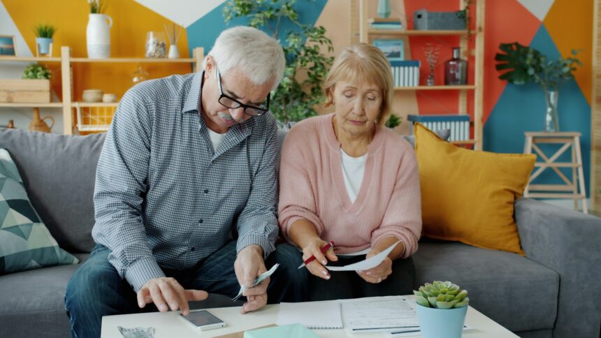 Elderly couple reviewing documents at home; social security trust fund 2032