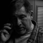 man wears grey plaid dress shirt; elder fraud