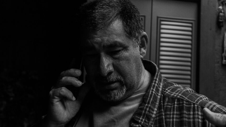 man wears grey plaid dress shirt; elder fraud