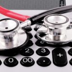 a stethoscope sitting on top of a calculator; medical debt