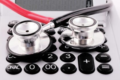 a stethoscope sitting on top of a calculator; medical debt
