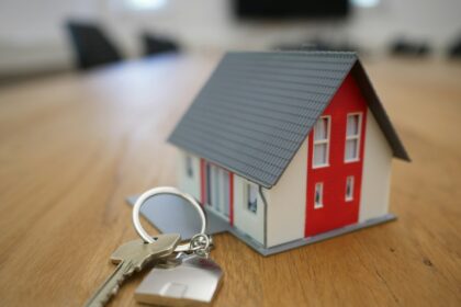 white and red wooden house miniature on brown table; source-level verification
